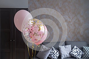 Pink balloons in the interior of a dark gray room of a teenage girl