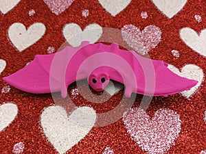 Pink bat on a hearts background photo