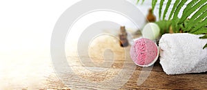 Pink bath bomb with towel  on wooden background.