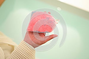 pink bath bomb on woman hand, relaxation time
