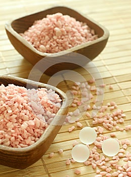 Pink bath salts in wooden bowls.