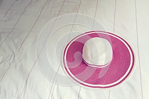 Pink beach hat on bed