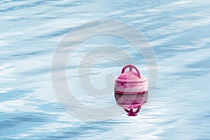 A pink beacon buoy in the sea