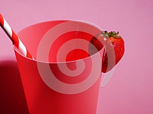 Pink beaker with strawberry and drinking straw