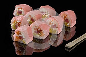 Pink beaters and wooden sticks for sushi on black acryle