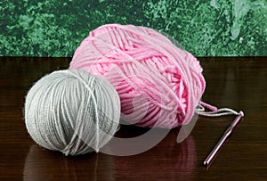 Pink and Beige Crochet Yarn with Crochet Hook on a Polished Wooden Table Top