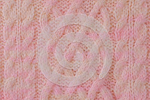 Pink and beige detail of a knitted item. Terry knitted texture as a macro photo background
