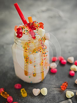 Pink berry milkshake with whipped cream, dripping sauce and candy`s