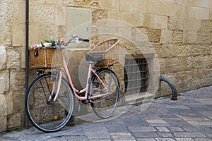 Pink bicycle parked at a side on a street