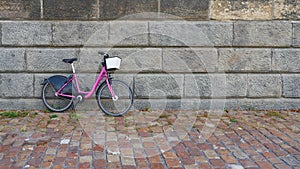 Pink bicycle parked on a wall on the banks of the Vltava River in Prague