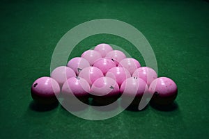 Pink billiard balls on a green pool table