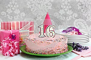 Pink Birthday cake with colorful sprinkles and the number 16 on top