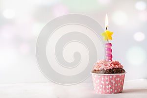 Pink Birthday Cupcake with Candle Light Background with Bokeh