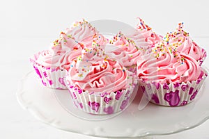 Pink birthday cupcakes on cake stand