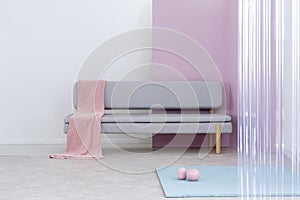 Pink blanket on a modern sofa in a simple living room interior.