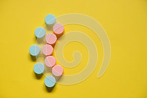 Pink and blue contact lens cases on yellow background with empty copy space