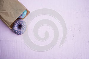 Pink and blue donuts in a paper bag