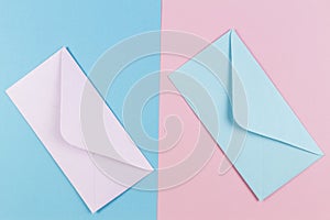 Pink and blue envelopes on colored pink and blue background. Top view.