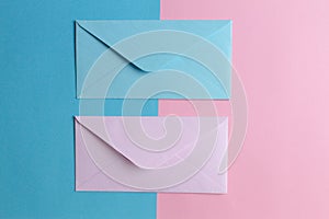 Pink and blue envelopes on colored pink and blue background. Top view.