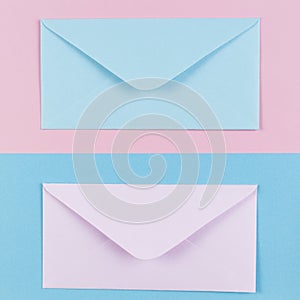 Pink and blue envelopes on colored pink and blue background. Top view.