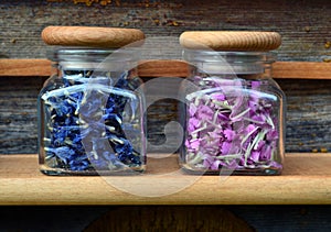 Pink and blue flowers in transparent jars