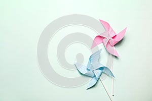 Pink blue paper spinners on light background. Kids toys colorful pinwheels on celebration party background. Top view, flat lay