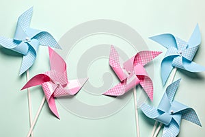 Pink blue paper spinners on light background. Kids toys colorful pinwheels on celebration party background. Top view