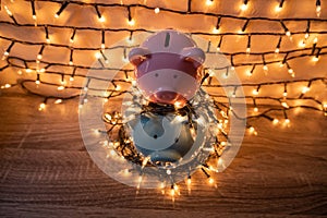 Pink and blue piggy bank with glittering lights, organize parties for successful activities to save money for retirement