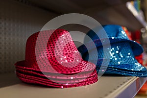 Pink and blue shiny hats with sequins for party or holiday celebration. Birthday accessories on supermarket shelf