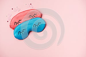 Pink and blue sleeping eye masks on pink paper background
