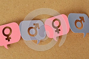 Pink and blue speech bubbles with female and male gender symbol linked together in a chain - Concept of communication between men