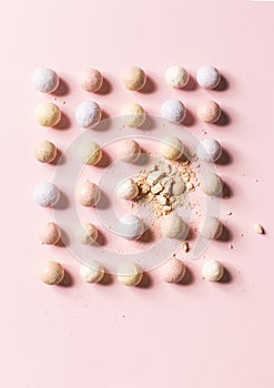 Pink blusher balls in a row on a pink background.