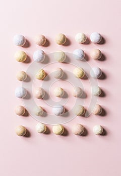 Pink blusher balls in a row on a pink background.
