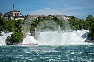 Pink boat float at rock observation on flowing river under the Rhein fall for background