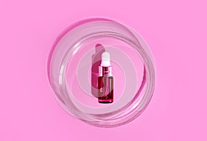 Pink bottle. Laboratory glass petri dish with pipette of water, serum, oil, beauty product. Natural medicine