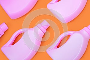 Pink bottles with chemicals for cleaning on an orange background. Seamless pattern