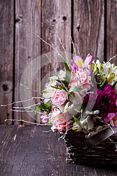Pink bouquet from gillyflowers and alstroemeria in the basket on