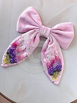 pink bow with embroidered delicate beautiful flowers in
