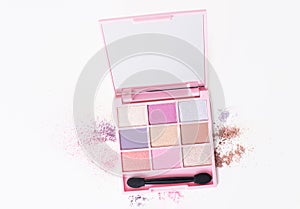 Pink box of eyeshadow make-up with powder spilled around the edges photo