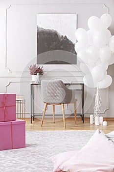 Pink boxes with presents on floor of elegant room ready for birthday hoopla