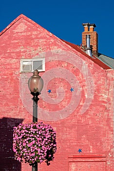 Pink brick wall , pink flower fireplace pipe ,street light pole and blue sky under sunlight in Georgetown