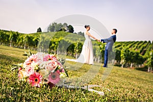 Pink Bridal Bouquet and Newly Weds Holding Hands in the Blurry B