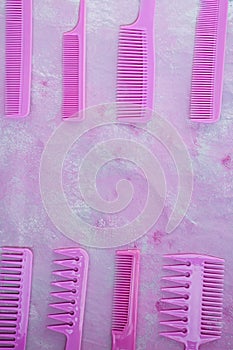 Pink bright comb for hairdressers. Beauty saloon. Tools for hairstyles. Pink background. Barbershop. Set of different hairbrushes