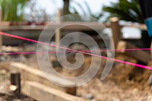 Pink builders string-line closeup on constructions site in selective focus