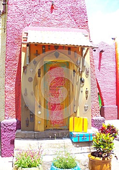 Pink building and a unique door featuring many different door knockers