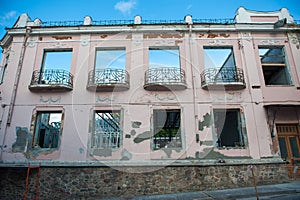 Pink building without windows and doors, looking to the sky