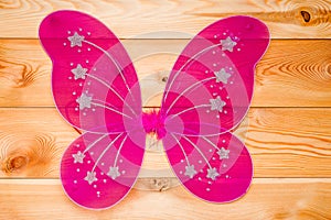 Pink butterfly wings costume for a carnival for a girl on wooden