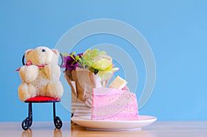 Pink cake and bear doll on blue background,break time,select focus.