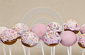 Pink cake pops on grey background