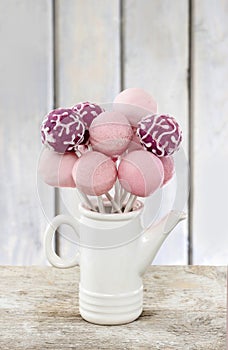 Pink cake pops on wooden table
